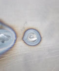 Close-up of a welded hole on a metal panel showing the work of Hole Plug Magnet XL Hands Free Weld Tool With Pivoting Magnetic V-Pad Base.