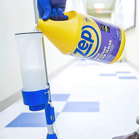Pouring Badass Professional Floor Sealant With Tough Stain Guard for Vinyl VCT and Concrete from a one-gallon jug.