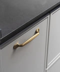 Six Pack 5 Inch Center To Center Arch Cabinet Pulls In Champagne Bronze Finish mounted on a kitchen drawer