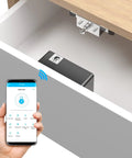 Bluetooth Drawer Lock For Cabinets With RFID And NFC shown inside a wooden drawer, smart lock operated via smartphone app display