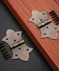 Antique Bronze Gold Flower Metal Butt Hinges For Cabinets And Jewelry Boxes 57 By 31mm with screws, displayed on a wooden surface.