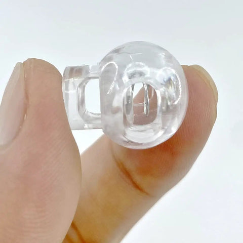 Close-up of transparent orb from Roman Shade Orbs Lock Rope Buckle Kit for Easy Leveling of Window Treatments, held between fingers.