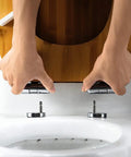 Hands installing Heavy Duty Solid Wood Elongated Toilet Seat With Smooth Soft Close Lid Quick Release Hardware and Nonslamming Design.