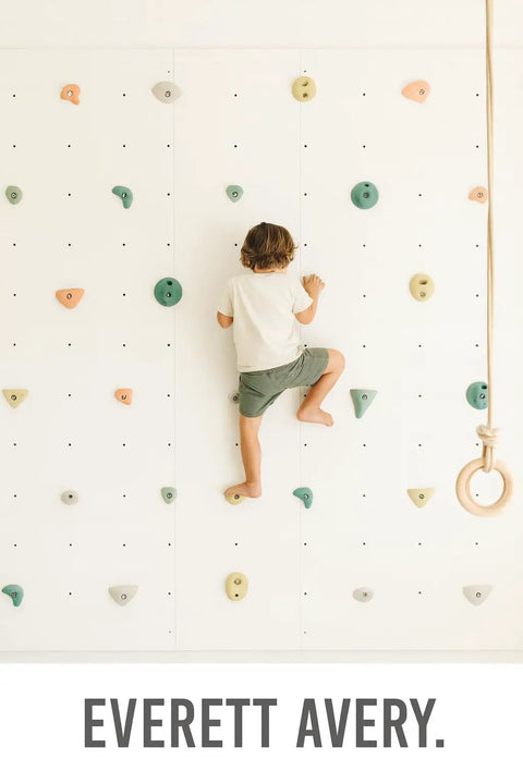 Child climbing on indoor wall with Premium Boho Rock Climbing Holds for Kids Indoor Wall Set in Earth Tones Durable Climbing Wall Props