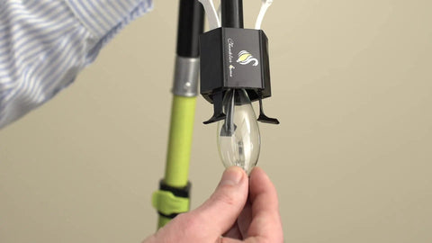 Candelabra Bulb Changer For Chandeliers No Ladder Needed tool in use with bulb, showing pole attachment detail.