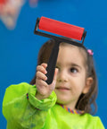 Child holding a red Slick Glide Plastic Ink Roller for Printmaking and Diamond Art Projects, ideal for crafting.