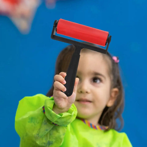 Child holding a red Slick Glide Plastic Ink Roller for Printmaking and Diamond Art Projects, ideal for crafting.