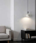 Terrazzo Small Pendant Light, 4.7 Inch Chrome Hanging Fixture over a cozy reading nook beside a beige sofa.