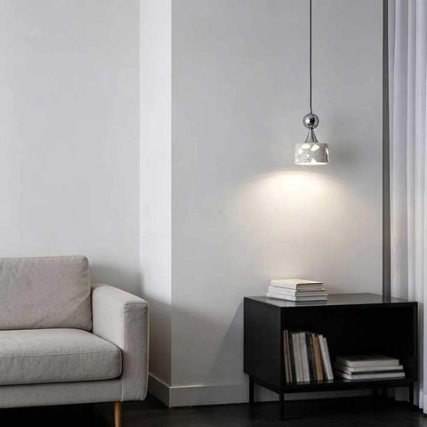Terrazzo Small Pendant Light, 4.7 Inch Chrome Hanging Fixture over a cozy reading nook beside a beige sofa.
