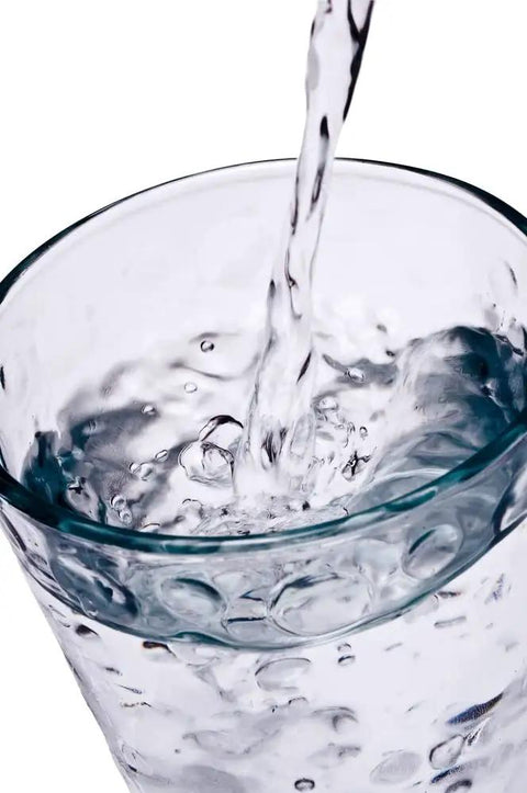 Clear water being poured into a glass, representing purity tested by the H2O OK Plus Complete Water Analysis Kit With 23 Tests.