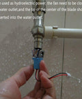 Hands holding a component of the Wind Hydroelectric Generator Model For STEM Classrooms, Hands On Renewable Energy Teaching Kit With Quick Assembly Parts To Demonstrate AC Wind Power Gen Principles near a water outlet, demonstrating assembly.
