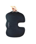 Upgraded Memory Foam Seat Cushion For Sciatica And Back Pain Relief, black coccyx support pillow being held by a hand.