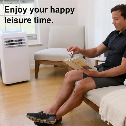 Man reading on sofa with portable air conditioner in room, enjoying leisure time.