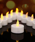 12 Pack Flameless Tea Lights LED Candles with Realistic Flicker and Cozy Warm Yellow Glow for Halloween Decor on black surface