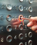 Person using No Touch Door Opener Tool With Stylus And Button Pusher on elevator button, rose finish