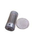 Beefy Flexible Shaft Coupler With Coiled Steel Springs 2 Pack Rock Solid Vibration Control And Seamless Misalignment Fix Smooth Power Transfer 8 Mm Bore Holes Garage Ready beside a coin for size reference.