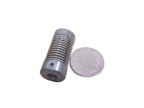 Beefy Flexible Shaft Coupler With Coiled Steel Springs 2 Pack Rock Solid Vibration Control And Seamless Misalignment Fix Smooth Power Transfer 8 Mm Bore Holes Garage Ready beside a coin for size reference.
