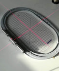 Red crosshair alignment projector tool; circular gray frame with grid for screen printing and fabric cutting, front view