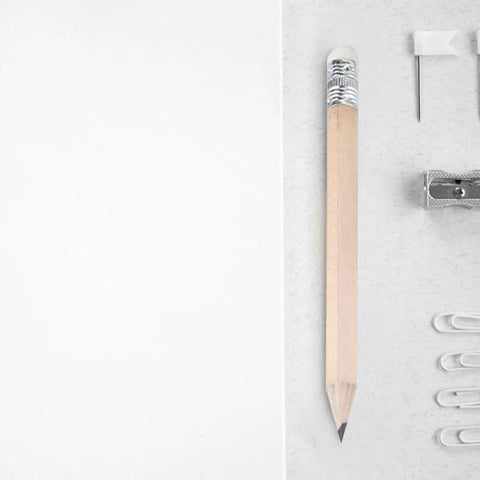 Mini wooden pencil with HB graphite and white eraser next to paper clips, sharpener, and pin. 60 Pcs Mini Wooden Pencils With HB Graphite And White Erasers.