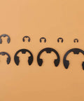 Various sizes of black metal E-clips from the 300 Piece E Clips Assortment Kit In Black Metal For Shafts And Housings Durable Retaining Rings Set