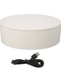 Top Shook Rotating Turntable Stand For Product Photography With USB Power And AAA Battery Option, white circular base and USB cable.