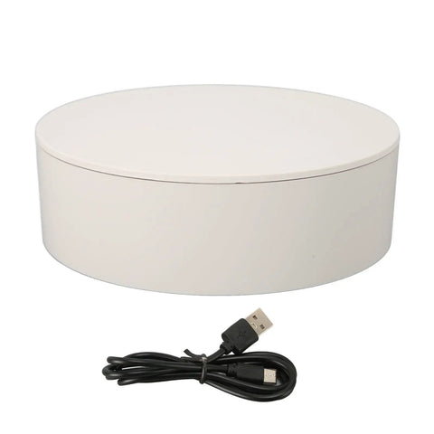 Top Shook Rotating Turntable Stand For Product Photography With USB Power And AAA Battery Option, white circular base and USB cable.
