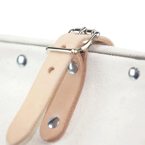 Close-up of leather buckle strap on Heavy Duty Natural Canvas Tool Bag Tote With Wide Hinged Opening And Leather Handles, 12 Inch Multi Purpose Tool Carrier, Rivet Reinforced Steel Frame, Moisture Resistant Vinyl Bottom, Non Scratch Feet, Built Tough