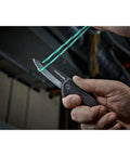 Dead Simple Pocket Knife With Smooth Slide Action And Heavy Duty Plastic Guard compact black hand tool cutting through rubber band.