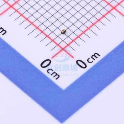 Close-up of a gold ESD diode DFN0603-2 ESD7381MUT5G on a gridded background
