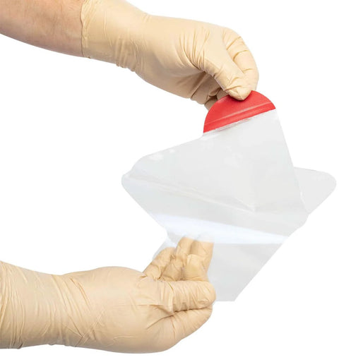 North American Rescue HyFin Vent Chest Seal twin pack; transparent seal with red pull tab opened by gloved hands.