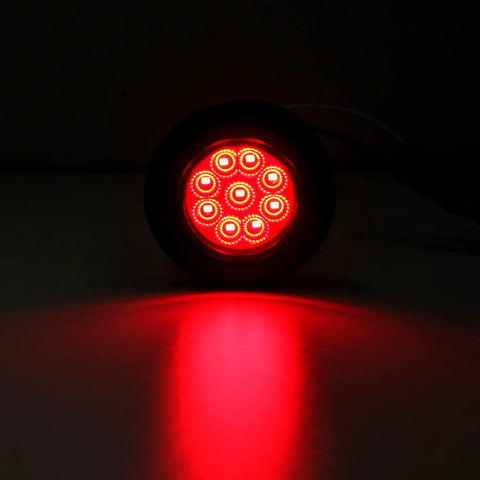 Red glowing Trucker Grade 2 Inch Round LED Marker Light with reflectors for truck RV and trailer side clearance lights.