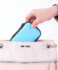 Compact Purple Charger Organizer Storage Case Durable Hard Shell being placed in a pink handbag for easy tech storage.