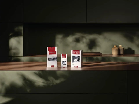 Milk Pipework Cleaner For Coffee Machines, 100 Sachets, boxes displayed on a wooden shelf with a dark background