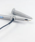 Close-up of 100MHz Oscilloscope Probe Kit with BNC clip probes and attenuation adjustable 1x or 10x grounding alligator clip.