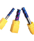 Three HUBBIQ 4-flute carbide end mills with blue-coated flutes in yellow plastic holders