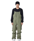 Man wearing army green waterproof ski bibs, winter snow pants for snowboarding, breathable high stretch, all day warmth and mobility.