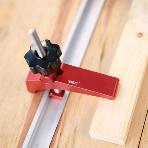 Rock Solid Aluminum T Track Hold Down Clamps For Woodworking And Metalworking Projects Plus Quick Slide In T Slot Press Clamps showing a red hold down clamp adjusting on wood.