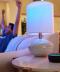 Hella Compact Smart Speaker With Alexa Built In Drops Kickass Soundwaves Smooth For Cozy Rooms Stereo Pairing Ready Charcoal Shell on table.