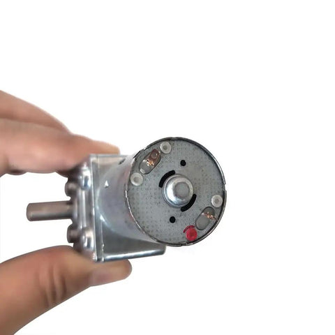 Close-up of 12V DC Worm Gear Motor With Dual Output Shafts Dope Torque in hand, showcasing metal casing and dual shafts
