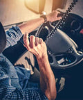Driver using 4 Pin CB Radio Microphone Replacement with Ergonomic Grip, Rugged Build, Clear Sound, 8 Foot Coiled Cord in a truck.