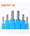 Carbide end mills set in blue plastic holders; seven spiral-flute cutters of varying diameters.
