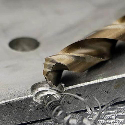 M42 cobalt twist drill bit, gold-colored, cutting into a metal workpiece (close-up).
