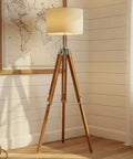 Vintage Teak Wood Tripod Floor Lamp with Chrome Finish 55 Inch Tall Nautical Inspired Rustic Modern Home Decor for Living Room or Den Shade Not Included Durable Steel and Aluminum Construction Unique Gift Idea in cozy room setting.