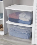 Clear Plastic Storage Containers With Snap Lids 58 Quart Medium Organization Bins holding neatly folded clothing in a closet.