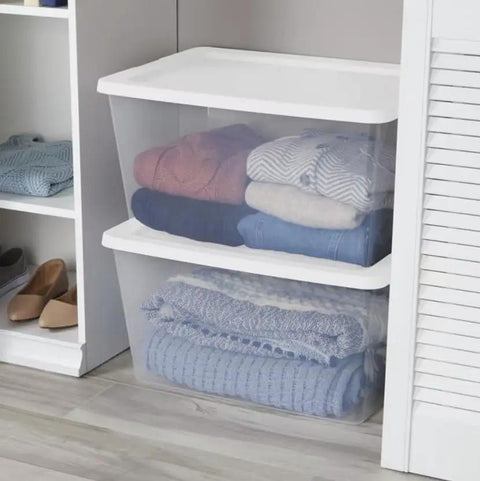 Clear Plastic Storage Containers With Snap Lids 58 Quart Medium Organization Bins holding neatly folded clothing in a closet.