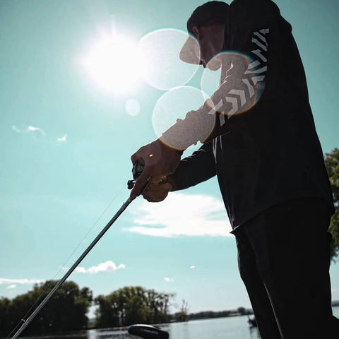 Person fishing with Laguna LT Spinning Reel 3 Plus 1 Ball Bearings 5.3 to 1 Gear Ratio with Auto Tournament Drag near lake.