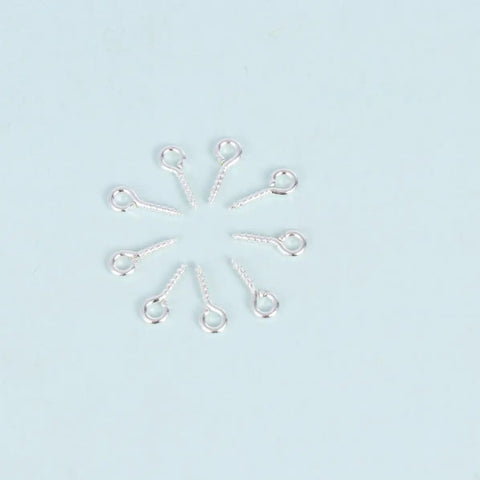 Close-up of plated iron round eye hooks from 600-Piece Sheep Eye Screw Kit with self-tapping screws arranged in a circle.