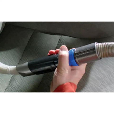 Hand using Dust Daddy Universal Vacuum Attachment For Quick Dust Busting In Tight Corners Flexible Micro Tube Design Reaches Around Objects Without Moving Them Dirt Remover For Home And Auto As Seen On TV