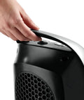 Hand holding carrying handle of Oscillating Ceramic Tabletop Space Heater With Adjustable Thermostat Carrying Handle Two Quiet Heat Settings and Fan Only Mode 11.6 Inches Silver Compact Space Saving Home Heating Solution