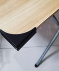 Heavy Duty Black Metal Corner Protectors Four Piece Set Straight Up Solid Edge Guards For Furniture Cabinets And Shipping Crates on a desk corner.